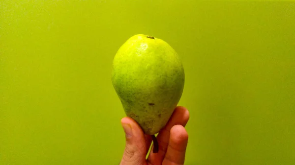 Hand Houden Van Groene Peren Vruchten Met Groene Achtergrond — Stockfoto