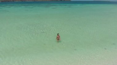 Kadın Balabac Filipinler Mansalangan Sandbar turkuaz su ve tropikal beyaz kumlu plajda yürüyüş