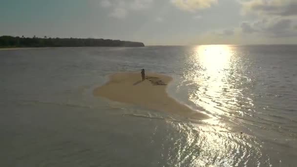 barre de sable tropicale aérienne Aloha écrit à partir d'étoiles de mer sur barre de sable candaraman. drone tournant autour pour Voyage couple marche sur le banc de sable au coucher du soleil à Balabac, Palawan, Philippines 