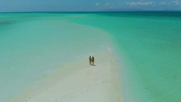 Aerial view travel couple walking at the sandbar in Canradaman island in Balabac, Palawan, Philippines — Stock Video