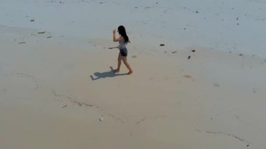 Koh Rong Adası'nda beyaz kumlu plajda dans eden kadının havadan görünümü 