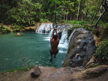 şelaleler havuzda ip ile sallanan adam, Filipinler Siquijor Adası'nda Cambugahay Falls