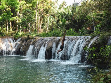 şelaleler havuzda ip ile sallanan adam, Filipinler Siquijor Adası'nda Cambugahay Falls
