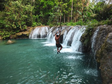 şelaleler havuzda ip ile sallanan adam, Filipinler Siquijor Adası'nda Cambugahay Falls