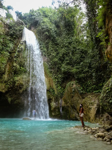 Filipinler Cebu Adası'nda İnambakan Şelalesi'nde gizli tropikal ormanda dağ geçidinden derin orman şelalesi yalnız kadın