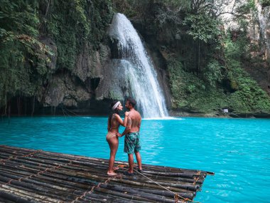 Cebu Adası Kawasan Şelalesi turkuaz su ile şelale önünde bambu sal üzerinde yalnız seyahat çift, Filipinler