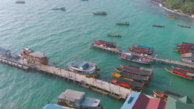 Kamboçya Koh Rong iskele ve Uzun Kuyruk Tekneler ile palmiye ağaçları ile çevrili Koh Touch köy kıyısı hava manzara. Tropik adada turistik yerler. Egzotik tatil beldesi