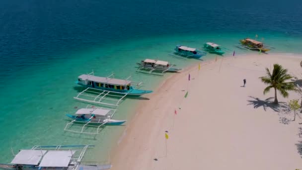 フィリピン パラワン州コロンのパス島の白い砂の上に駐車中の観光船に映画ドローンの動き — ストック動画