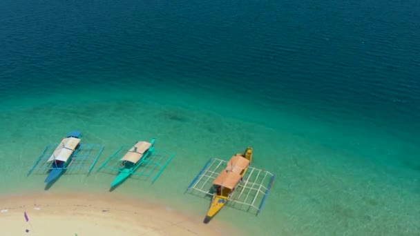 フィリピン パラワン州コロンのパス島の白い砂の上に駐車中の観光船に映画ドローンの動き — ストック動画