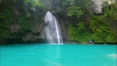 Cebu Adası, Filipinler 'deki Kawasan Şelalesi. Tropikal yağmur ormanlarında güzel bir şelale. Doğal yüzme havuzu ve dağ nehri kanyonunda bambu salı olan bir şelale..