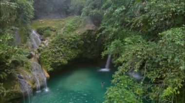Filipinler 'deki Cebu Adası' ndaki Kawasan Şelalesi üzerinde tropikal yeşil habitatı olan hava şelalesi manzarası.