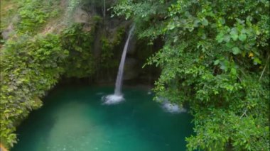 Filipinler 'deki Cebu Adası' ndaki Kawasan Şelalesi üzerinde tropikal yeşil habitatı olan hava şelalesi manzarası.