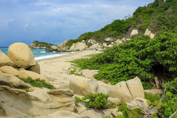 Kolombiya 'nın Cabo San Juan del Guia kentindeki Tayrona Ulusal Parkı' nda etrafı tropikal ormanlarla çevrili Karayip Denizi.