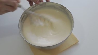 Lezzetli peynirli kek yapan kadın. Metal tencerede adım adım yanmış cheesecake hazırlama