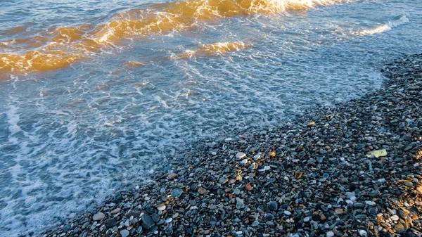 晴れた日には石のビーチ 浜の上から見た小石の背景 — ストック写真
