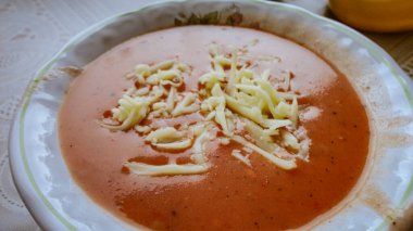 Fresh tomato soup with cheese in the white plate clipart