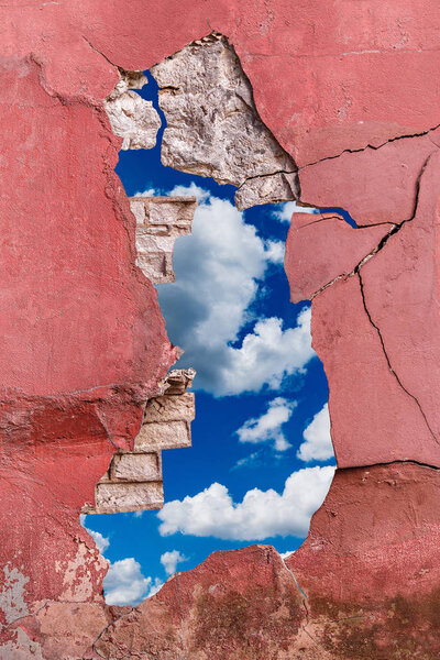 Ancient cement and brick wall with cracks on sky bacground.