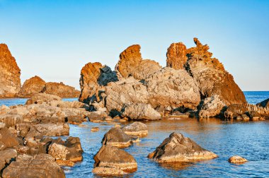 Gün batımında volkanik oluşumlar Acireale'da. Sicilya.