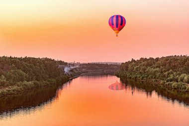 Sıcak hava balonu günbatımı zamanı nehirde yukarıda.