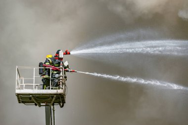 İtfaiye binanın üst tarafından bir yangın söndürmek.
