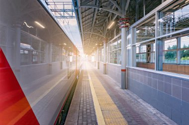 Yüksek hızlı tren istasyonu platformu tarafından günbatımı zaman duruyor..