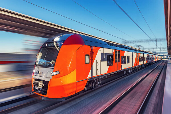 Современный скоростной поезд быстро движется по платформе
