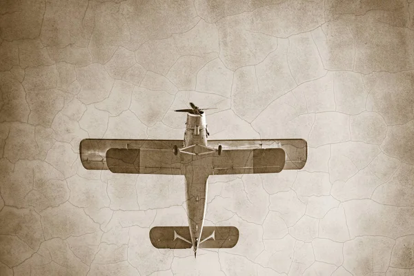 Old retro plane flies in the sky. Vintage style image.