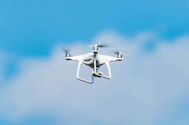 Mavi gökyüzünde yukarıda beyaz quadrocopter.