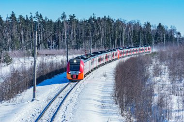 Modern high-speed train approaches to the station at winter morning time. clipart