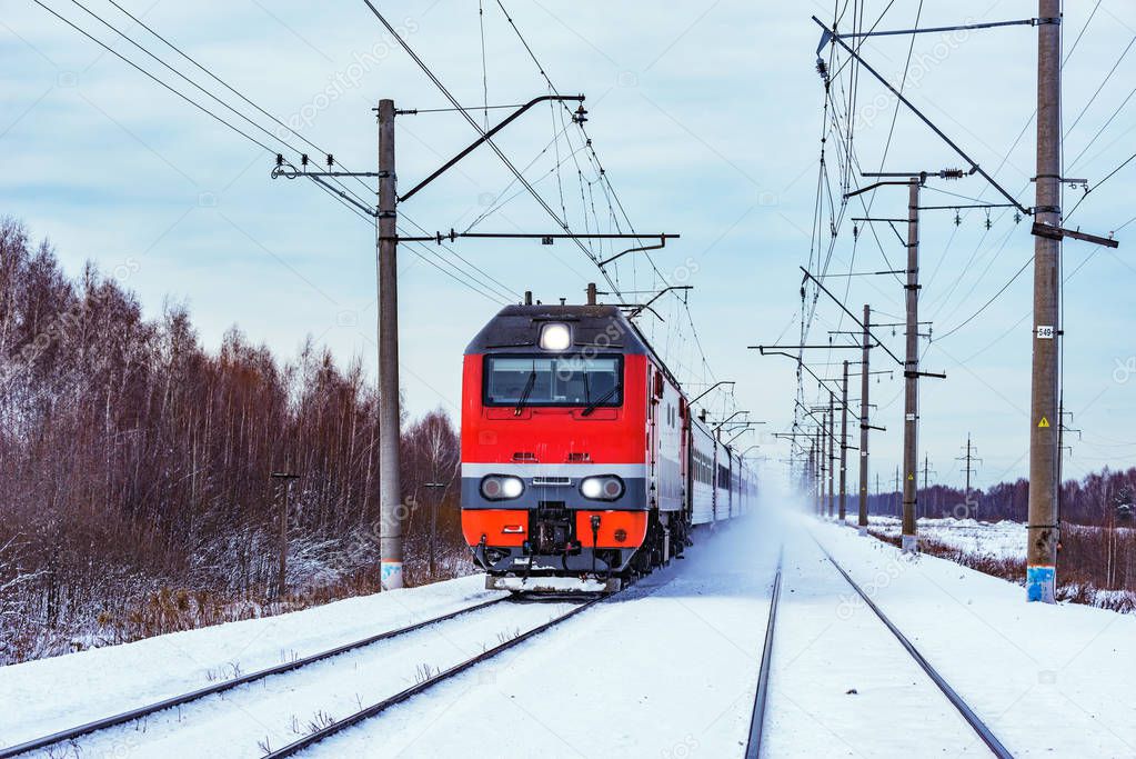 Modern high-speed train approaches to the station at winter morning time.