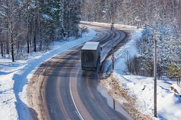 Грузовой грузовик движется по дороге в зимнее время суток. — стоковое фото