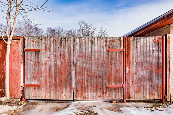 Dřevěné starobylé brány domu v jarním období. — Stock fotografie