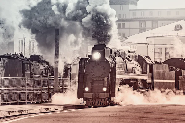 Parní vlak odjíždí z železničního nádraží. — Stock fotografie