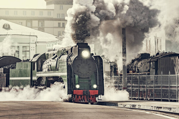 Steam train departs from the railway station.