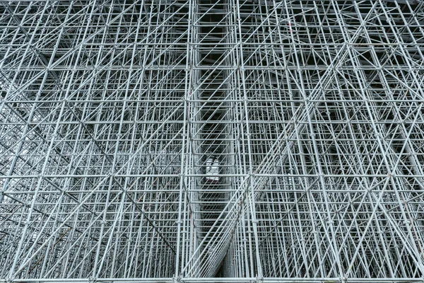 Vertical scaffolding formed a myriad of grid. Industrial and modern urban construction background. — Stock Photo, Image