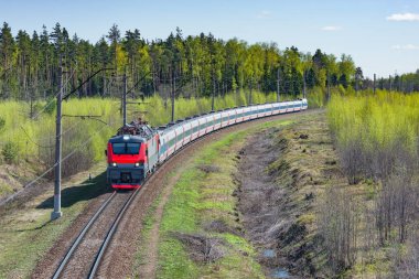 Modern yüksek hızlı tren ilkbahar sabahı istasyona yaklaşıyor.