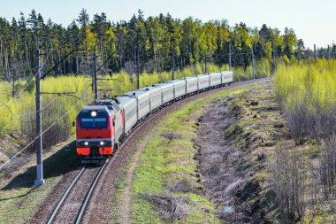 Yolcu treni ilkbahar sabahı istasyona yaklaşıyor.