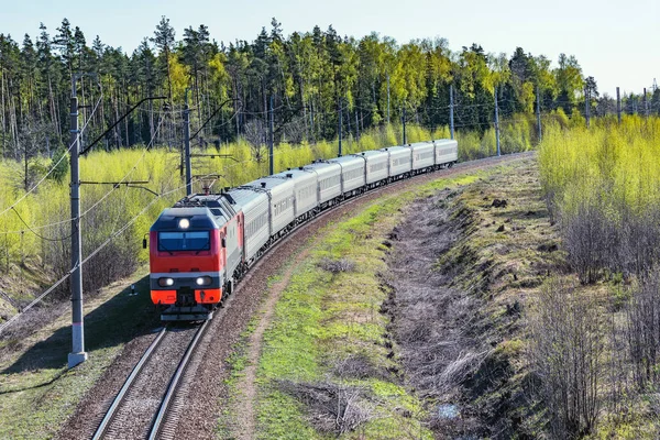 Tren de pasajeros se acerca a la estación en la mañana de primavera . — Foto de Stock