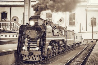 Retro tren tren istasyonu binasından yola çıkıyor.