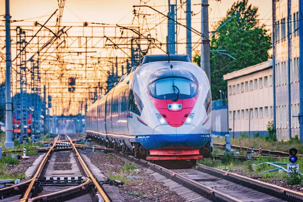 Пасажирський поїзд відправляється зі станції під час заходу сонця . — стокове фото