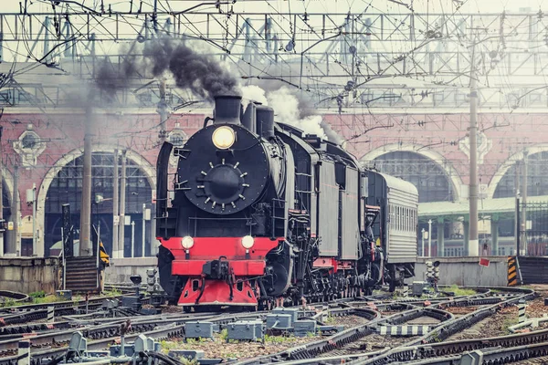 O trem retrô parte do prédio da estação ferroviária. — Fotografia de Stock