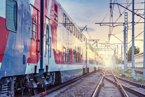 Tren de pasajeros sale de la estación al atardecer. — Foto de Stock