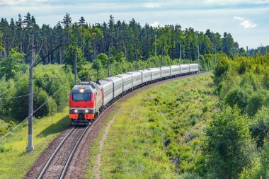Yolcu treni yaz sabahı istasyona yaklaşıyor.