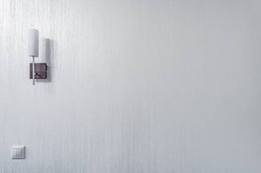 Beyaz oturma odası duvarında beyaz lamba.