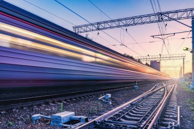 Yolcu treni gün batımı zamanında hızlı hareket eder.