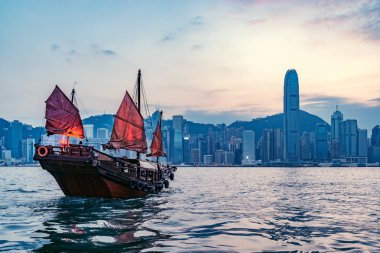 Günbatımında Hong Kong limanında küçük bir gemi..