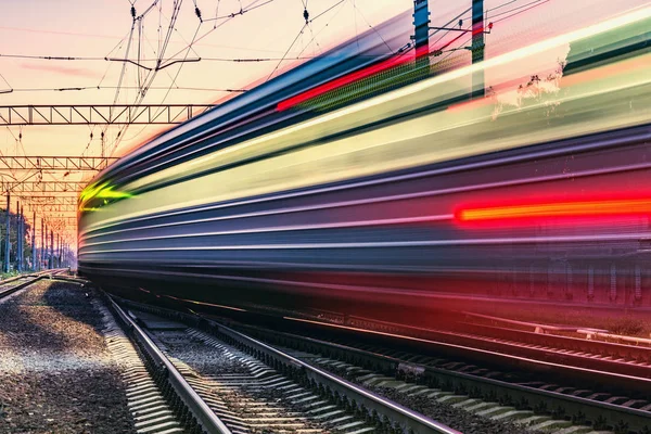 Passenger train moves fast at sunset time. — Stock Photo, Image