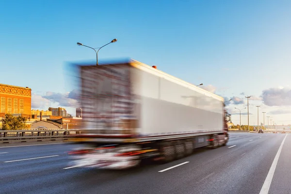 Ciężarówka porusza się szybko na autostradzie o zachodzie czasu. — Zdjęcie stockowe