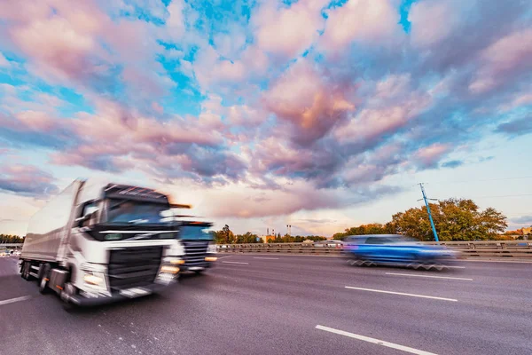 Ciężarówka porusza się szybko na autostradzie o zachodzie czasu. — Zdjęcie stockowe