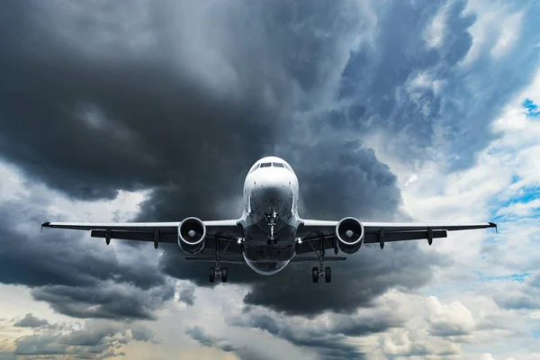 Landing passenger plane on dark cloudy sky background. — Stock Photo, Image